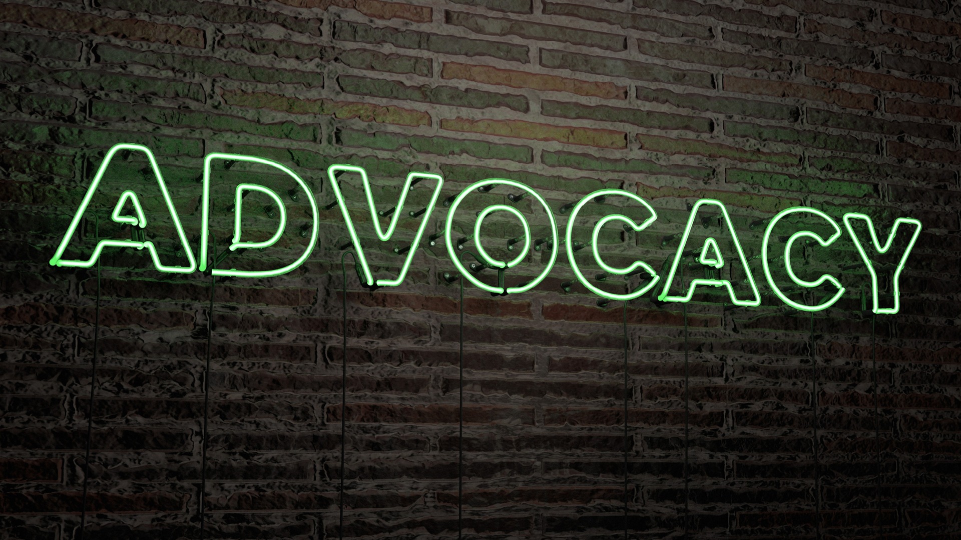 Green "ADVOCACY" neon sign ion a black brick wall