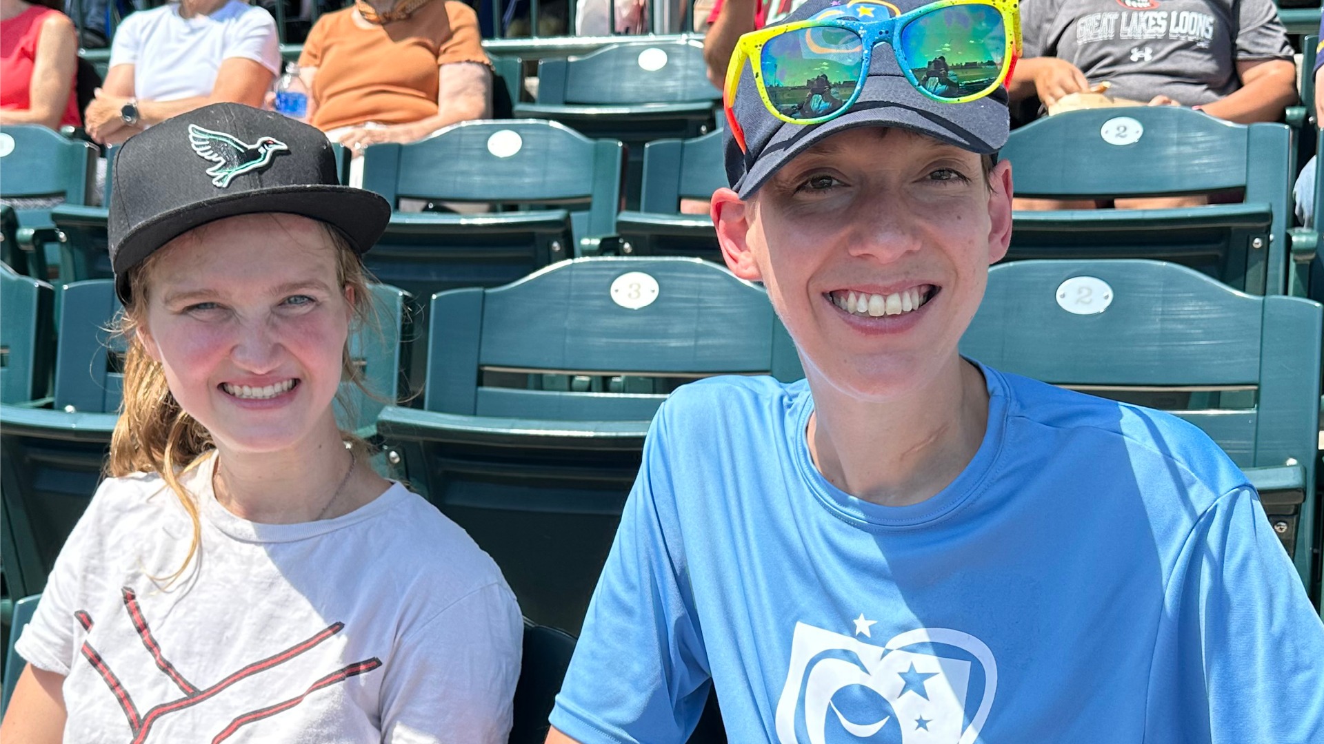 girl and boy sitting in the stands at Dow Diamond, smiling at Great Lakes Loons Corteva Inclusion Day