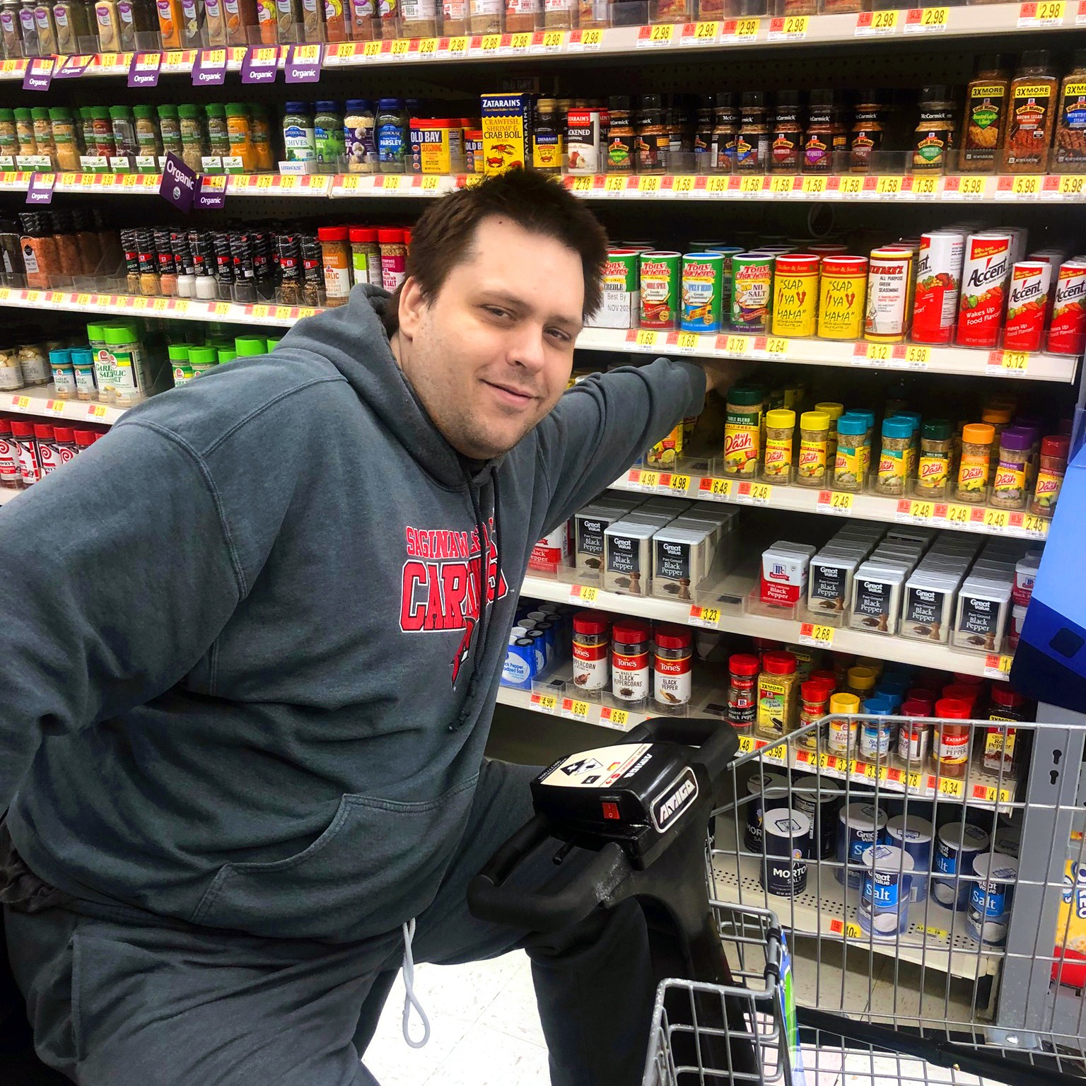 Nathan shopping for groceries in a motorized cart. Nathan is a Nursing Facility Transition Consumer.